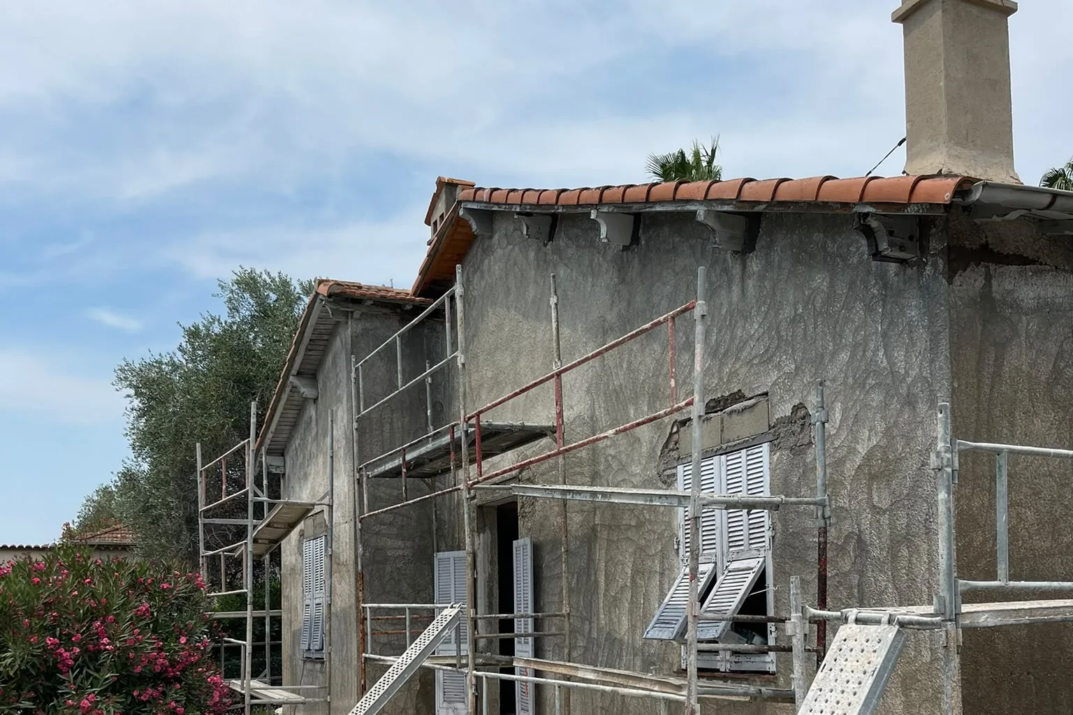 Façade de la maison d’Antibes en cours de décroûtage, bande purgée sous la rive de toiture