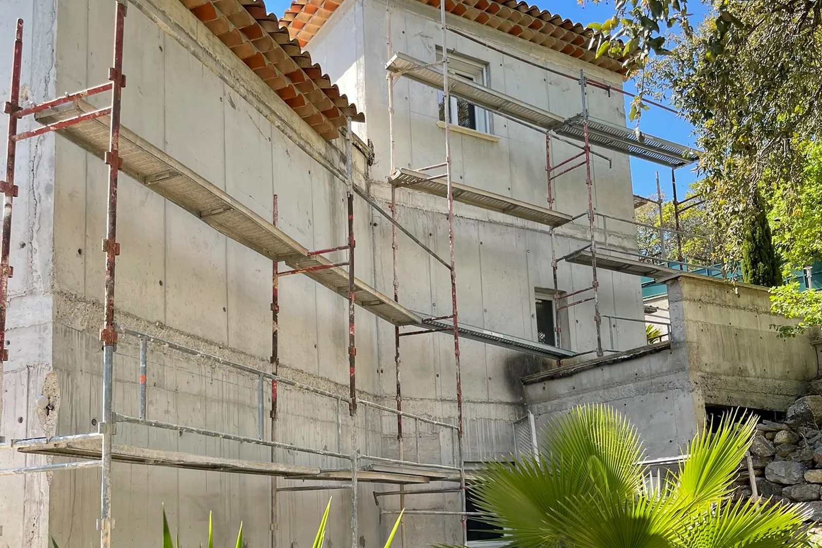 Pignon en béton banché sous échafaudage avant préparation